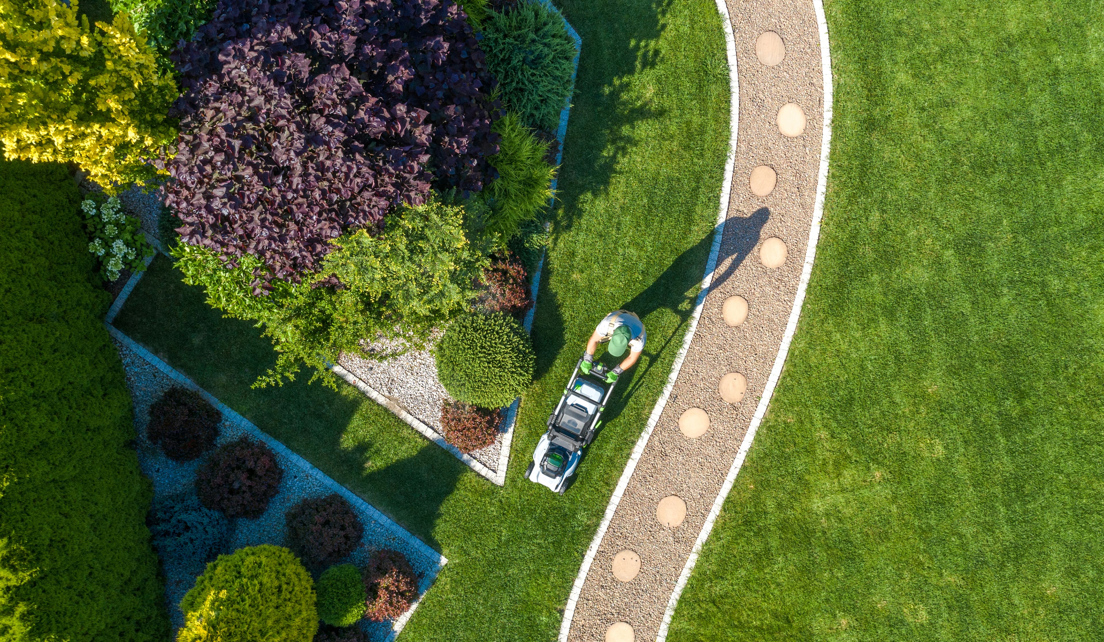 Vue aérienne d’un jardin paysager entretenu et d’une pelouse tondue.